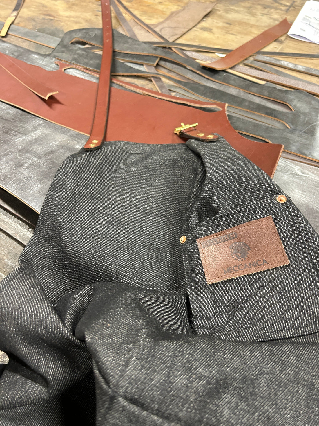Artisan belt maker crafting a selvedge denim apron with saddlery straps