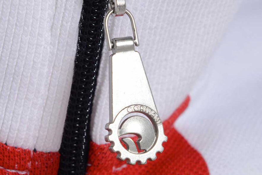 Close-up of a zipper pull with a logo on a multicolored background